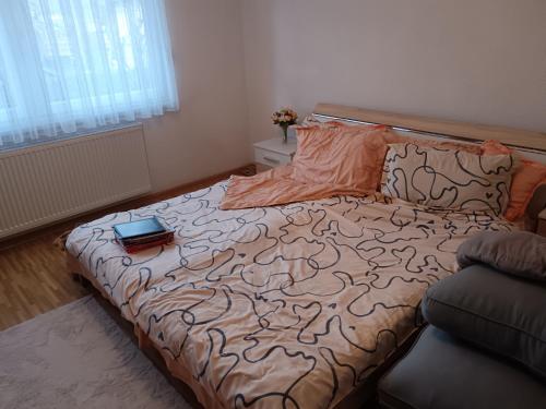 Un dormitorio con una cama con un libro encima. en Apartmani Srebrenik, en Srebrenik