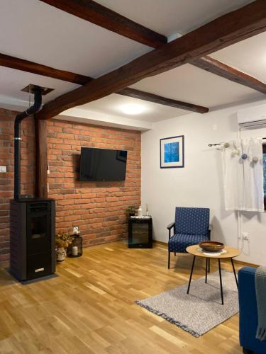 a living room with a fireplace and a brick wall at Kućice za odmor Šalatin jarek - Free tickets to local attractions in Ðurđevac