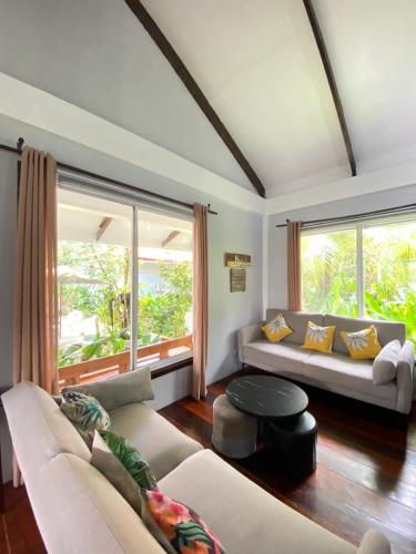 ein Wohnzimmer mit Sofa und großem Fenster in der Unterkunft Siargao Residency - Generator & Starlink in General Luna