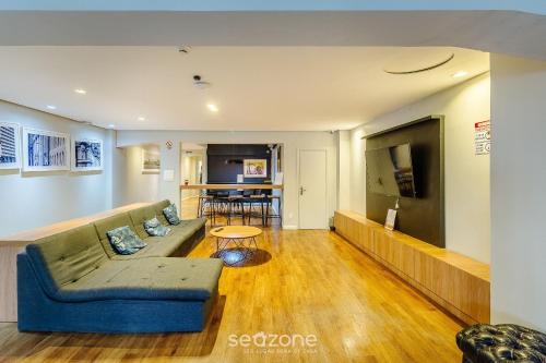 ein Wohnzimmer mit Sofa und Fernseher in der Unterkunft Estúdios no Centro Histórico de Poa - ELSs in Porto Alegre
