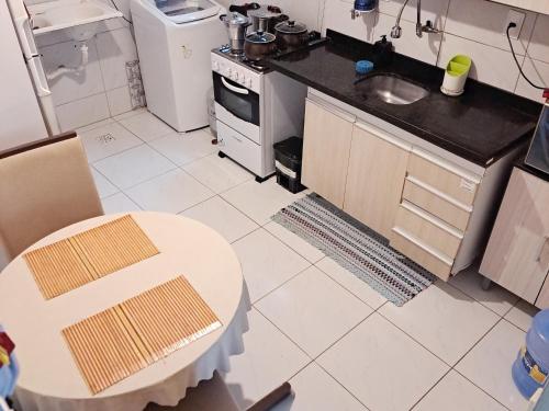 a small kitchen with a table and a stove at Suíte INDIVIDUAL com Ar condicionado em AP Compartilhado in João Pessoa