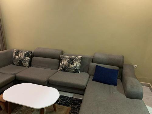 een woonkamer met een bank en een tafel bij Le Manoir in Kigali