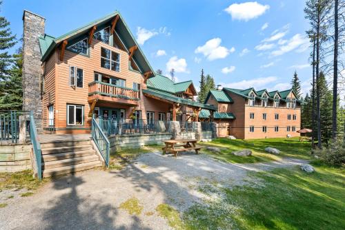 a large wooden house with a picnic table in front of it at HI Lake Louise Alpine Centre - Hostel in Lake Louise