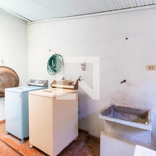 a kitchen with a refrigerator and a sink in a room at Apartamento 04 old no Capão da Imbuia in Curitiba