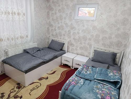 a bedroom with two beds and a window at Nakhchivan Family Home in Naxçıvan