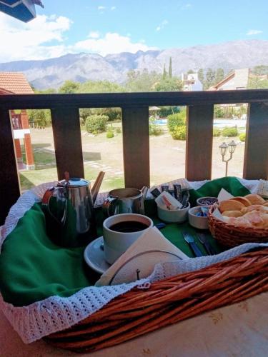 Posada Los Alamos في ميرلو: طاولة إفطار مع الخبز والقهوة على الشرفة