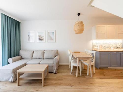 un salon avec un canapé et une table dans l'établissement Comfortable, convenient holiday apartment, à Grzybowo