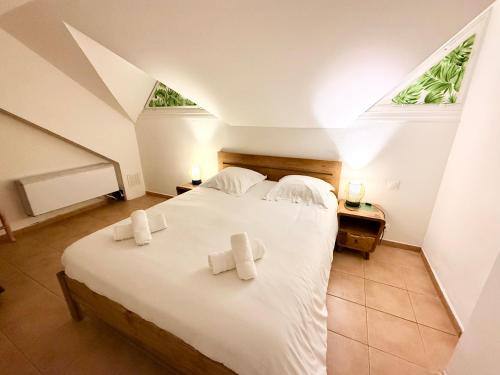 a bedroom with a large white bed with towels on it at Sur la Plage P&V Village Vacances Sainte-Anne in Sainte-Anne