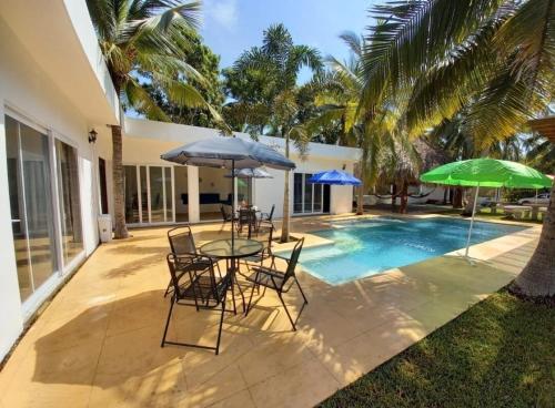 TaxiscoVilla Los Delfines 1的一个带桌椅和遮阳伞的庭院