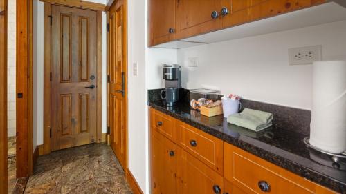 a kitchen with wooden cabinets and a counter top at 1117 Lodge At Spruce Peak Ski In Ski In Ski Out King Studio By Stowe Mountain Rentals in Stowe