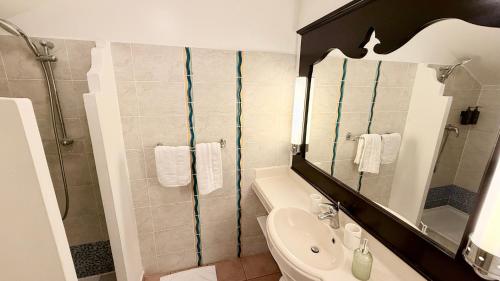 a bathroom with a sink and a mirror at Sur la Plage P&V Village Vacances Sainte-Anne in Sainte-Anne
