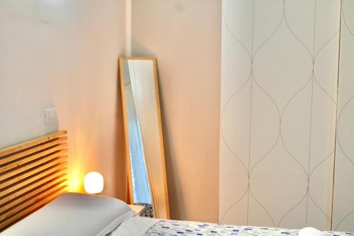a bedroom with a mirror next to a bed at The Green Gate - Airport Guest House in Pisa