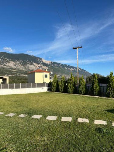 ein Grasfeld mit einem Gebäude und Bergen im Hintergrund in der Unterkunft Taras Studio in Karavádhos