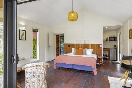 a bedroom with a bed and a table and chairs at The Hideout in Mangawhai