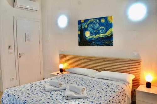 a bedroom with a bed with a painting on the wall at The Green Gate - Airport Guest House in Pisa