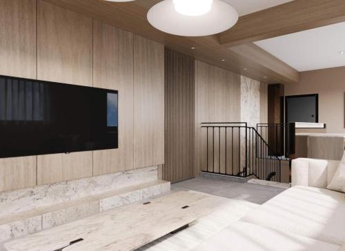 Una sala de estar con un televisor de pantalla plana en una pared. en Luxury Four-Bedroom with Large Terrace, en Tel Aviv