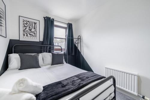 une chambre avec un lit noir et blanc et une fenêtre dans l'établissement Fraserburgh Apartment - 2 bed, free parking & wifi, à Fraserburgh