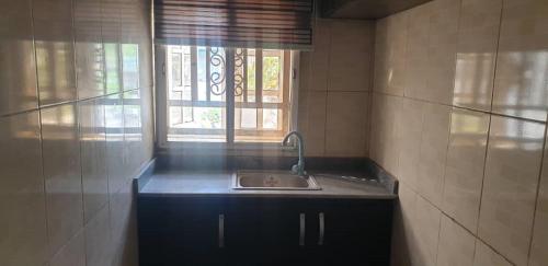 una cocina con fregadero y ventana en ED Apartment, en Mama