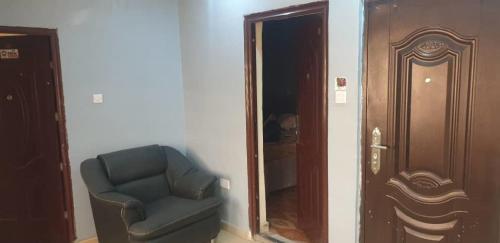 a living room with a chair and a mirror at ED Apartment in Mama