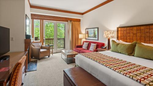 a bedroom with a large bed and a living room at 1234 Lodge At Spruce Peak Ski In Ski In Ski Out King Studio By Stowe Mountain Rentals in Stowe