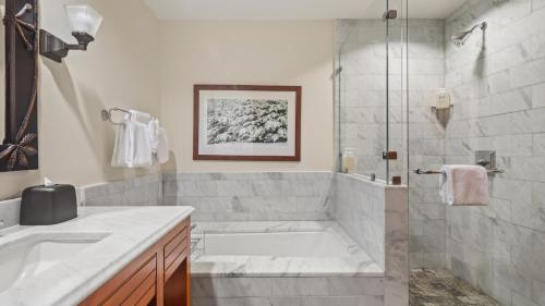 une salle de bain avec une baignoire, un lavabo et une douche dans l'établissement 1234 Lodge At Spruce Peak Ski In Ski In Ski Out King Studio By Stowe Mountain Rentals, à Stowe