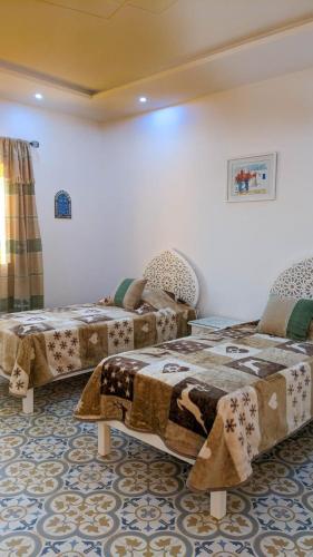 a room with two beds in a room at Djerba Dar Iyad in Mezraya