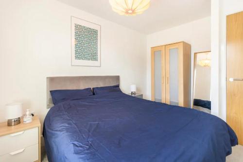 a bedroom with a blue bed with a blue comforter at Very Comfortable Rooms and Welcoming live in Hosts in Killingbeck