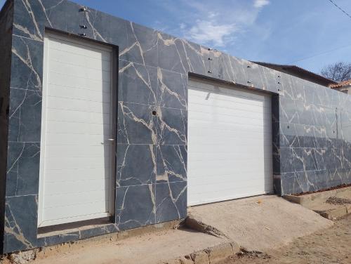 due porte da garage bianche su un edificio di Casa em Búzios 5 a Búzios