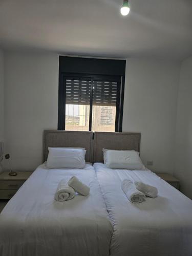 two beds with towels on top of them in a bedroom at Neveh Shamir Staycation in Beit Shemesh