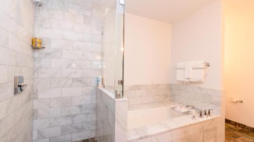 La salle de bains est pourvue d'une douche, d'une baignoire et d'un lavabo. dans l'établissement 1302 Lodge At Spruce Peak Ski In Ski Out Two Bedroom By Stowe Mountain Rentals, à Stowe