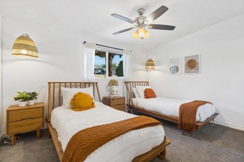 a bedroom with two beds and a ceiling fan at The Cosmic Casita in Joshua Tree