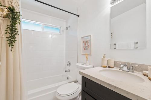 a white bathroom with a toilet and a sink at The Cosmic Casita in Joshua Tree