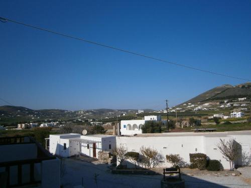 a view of a white building with mountains in the background at Eri Hotel in Parikia