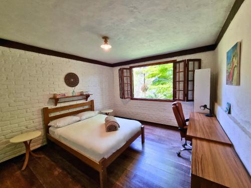 una camera da letto con un letto, una scrivania e una finestra di Rio Habitat - Maria Comprida ad Araras Petropolis