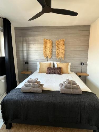 a bedroom with a large bed with towels on it at Van de Gruiterwonen in Axel