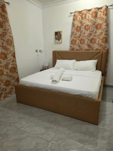 un lit avec des draps blancs et des serviettes dessus dans l'établissement Private en - suite room near airport, à Madina