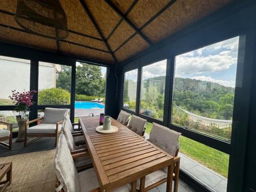 ein Wohnzimmer mit einem Tisch, Stühlen und einem Pool in der Unterkunft Ferienwohnung Panorama Oberkirn in Oberkirn