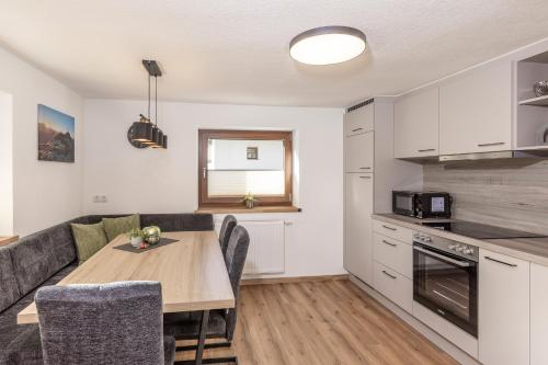 une cuisine et un salon avec une table et un canapé dans l'établissement Irmas Ferienhäusl, à Längenfeld