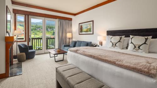 a bedroom with a large bed and a living room at 1434 - Studio - Spruce Peak Lodge - Stowe Mt Resort - Ski in Ski out - Sleeps 4 in Stowe