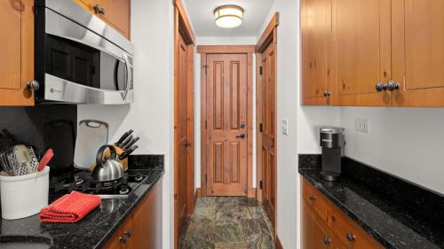 a kitchen with a stove and a microwave at 1434 - Studio - Spruce Peak Lodge - Stowe Mt Resort - Ski in Ski out - Sleeps 4 in Stowe