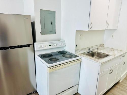 a small kitchen with a stove and a refrigerator at Casa Miami in Miami