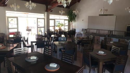 an empty restaurant with wooden tables and chairs at Hotel e Restaurante Chão Nativo in São José da Barra