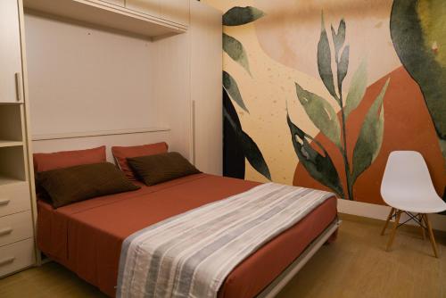 a bedroom with a bed with a painting on the wall at Appartamenti Armida in Chioggia