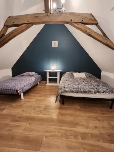 a attic bedroom with a bed and a table at Maison de campagne in Restigné