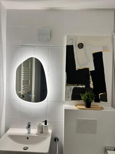 a white bathroom with a sink and a mirror at Modern City Apartment 1 in Munich