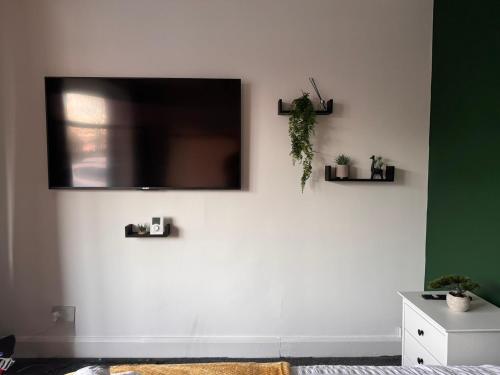 a living room with a tv on a white wall at Kenton Lane in Kenton