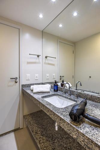 a bathroom with a sink and a large mirror at Luxo na Gloria in Rio de Janeiro