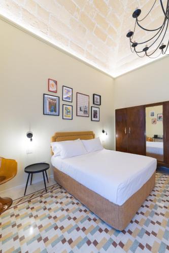 a bedroom with a large bed and a table at L'Ombra dell'Ulivo B&b in Marsala