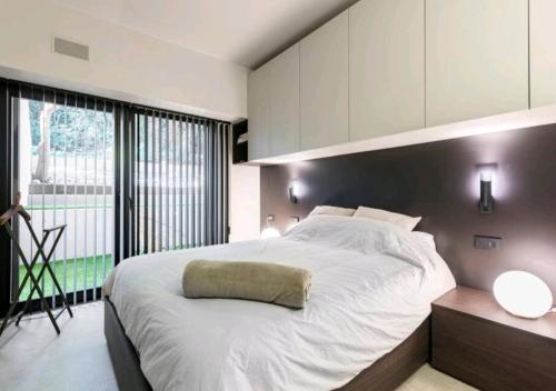 a bedroom with a large white bed and a large window at LagoC0C00N - Colazione - 300m stazione - 800m lago in Desenzano del Garda
