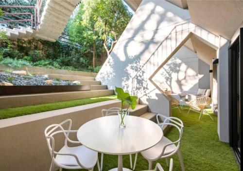 a patio with a white table and chairs and stairs at LagoC0C00N - Colazione - 300m stazione - 800m lago in Desenzano del Garda